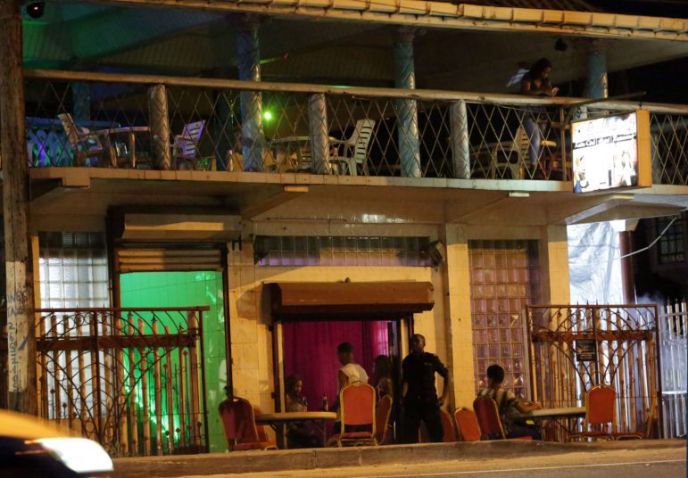 Un hombre revisa la bolsa de una mujer antes de entrar en el club nocturno de Bollywood en Providence, East Bank Demerara.